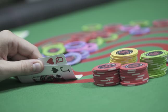 A person looking at his hand during live poker game