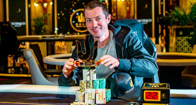 A picture of Tom Dwan with a poker trophy