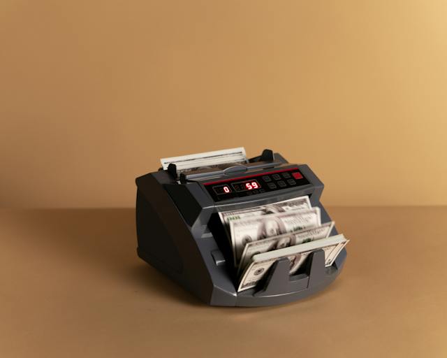 A picture of money counting machine, representing rake in poker